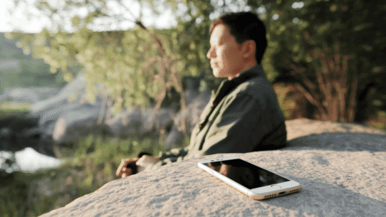 A person meditating without their phone nearby